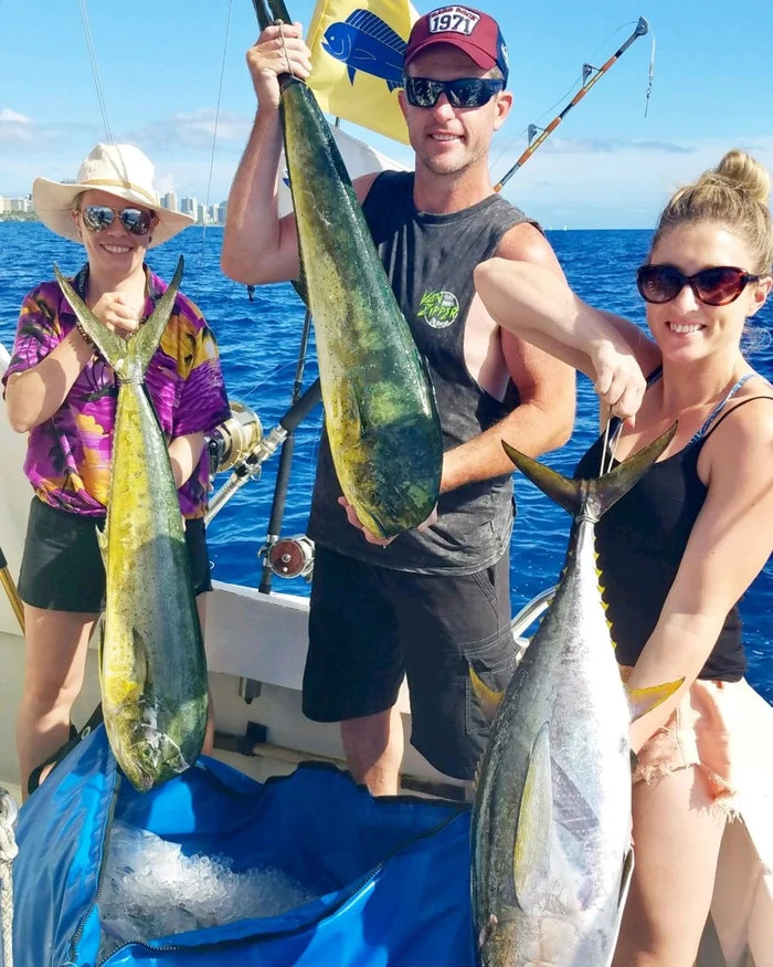 Guests sharing their catch on a Waikiki fishing charter