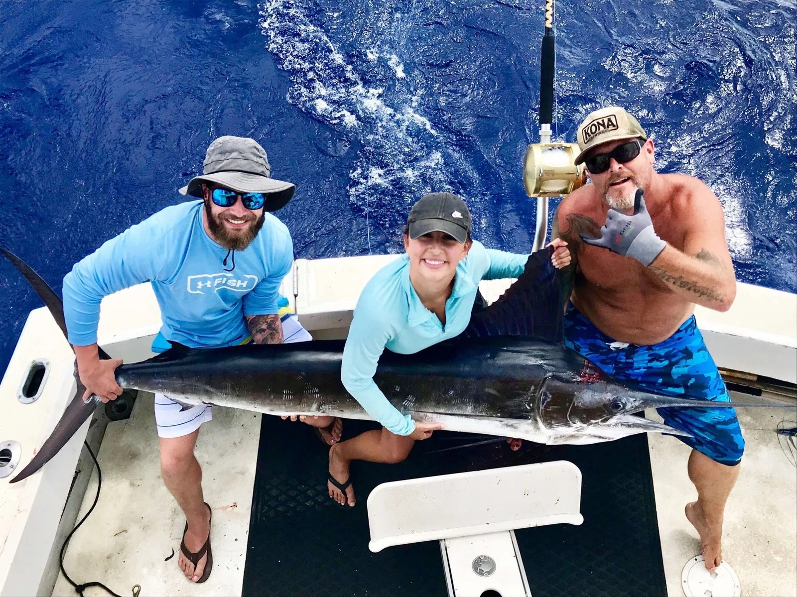Three anglers with their offshore catch aboard a Waikiki sport fishing charter